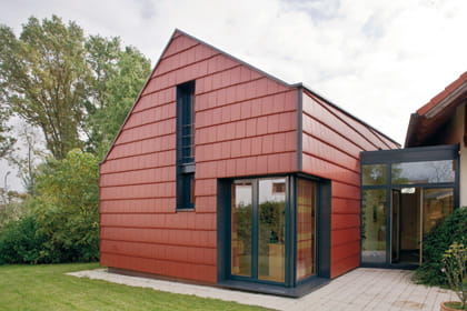 Haus mit roter Fassadenbekleidung.